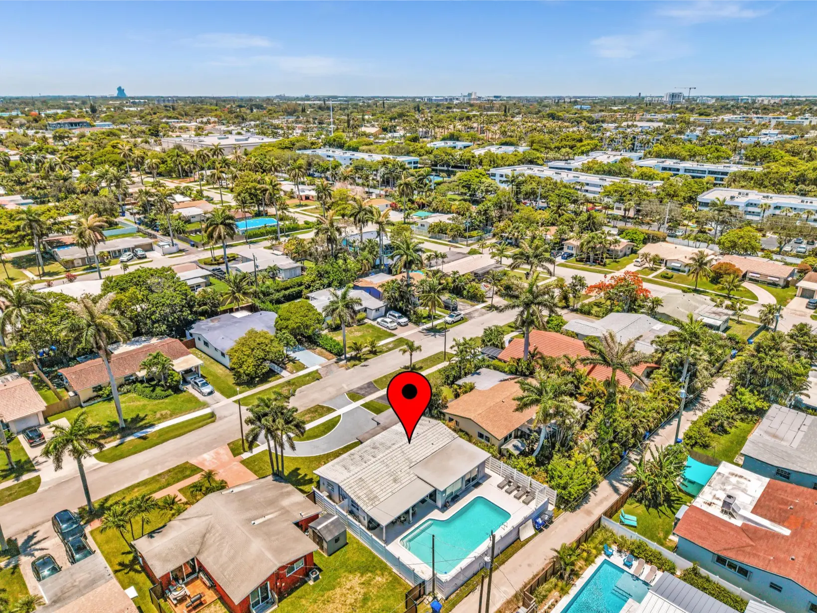 Aerial view of a palm-lined residential neighborhood with a highlighted home, commonly documented during rental property inspection.