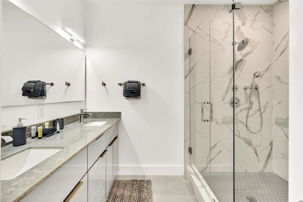 Modern luxury bathroom with marble shower and double vanity