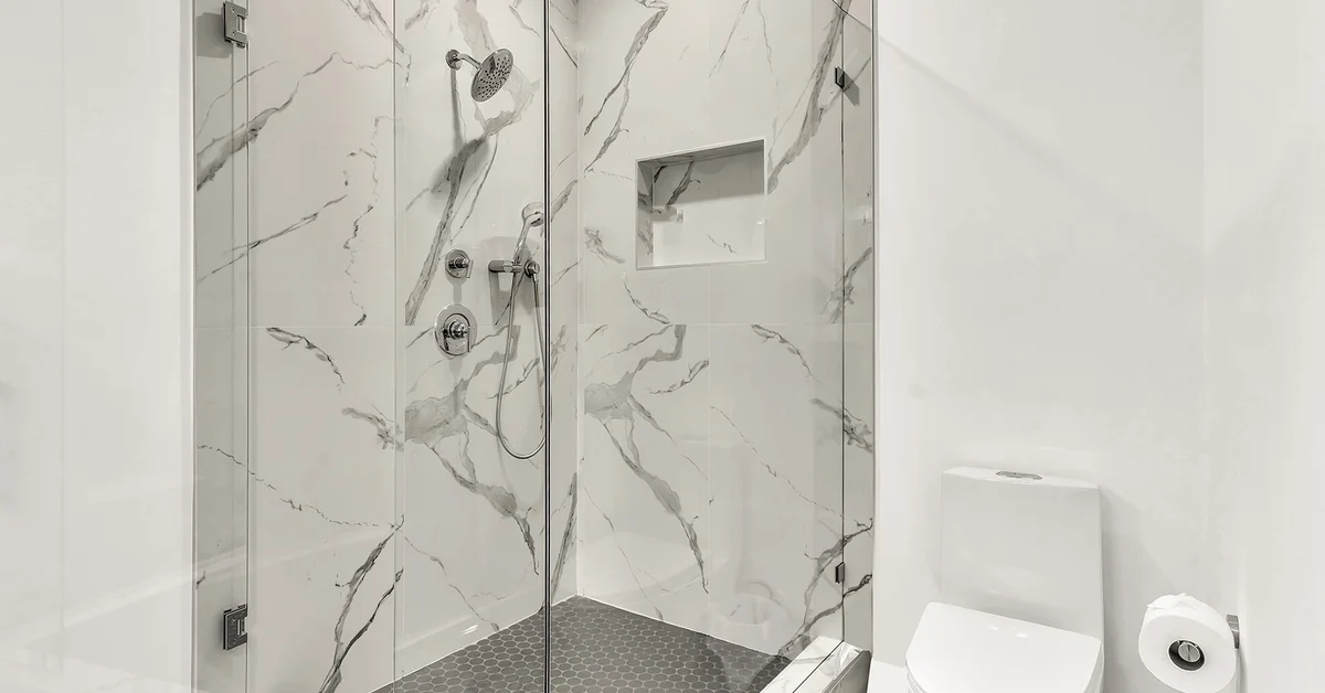 Luxury marble walk-in shower with glass doors and modern fixtures